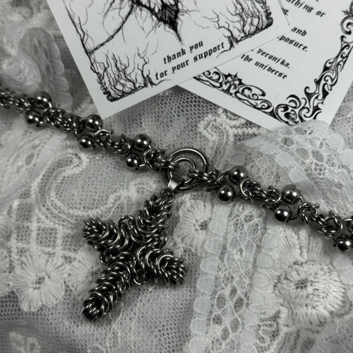 Wyjątkowy, mocarny ręcznie stworzony naszyjnik całkowicie wykonany starą techniką chainmail - żmudnego łączenia / plecenia metalowych kółek, dawniej używanej np. w rycerstwie do tworzenia kolczug, zbroi. Zawieszka - krzyż - stworzona również tą metodą.